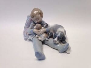 Child figurine with puppies and dog.
