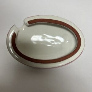 Oval ceramic ashtray with brown trim.