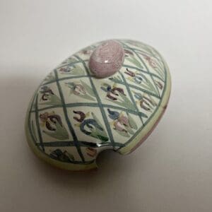 Decorative ceramic lid with floral pattern.