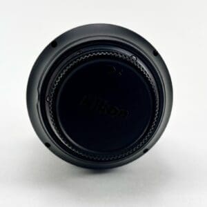 Nikon lens cap on white background.