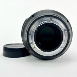 Camera lens with cap on white background.