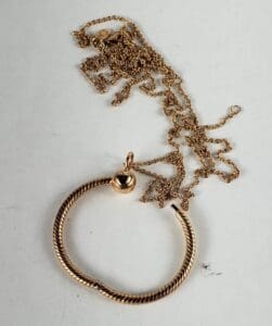Gold pendant with intricate chain design.