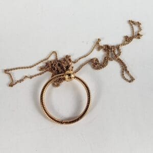 Gold necklace with round pendant.