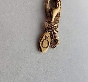 Gold chain with engraved oval pendant.