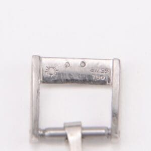 Silver watch clasp with engraved markings.