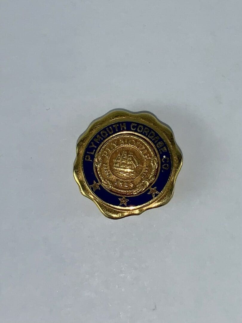 Gold Plymouth Cordage Co. pin on white.