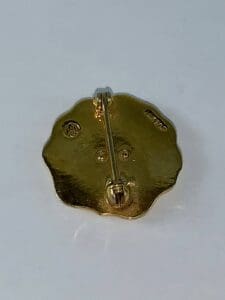 Gold brooch back with pin and markings.