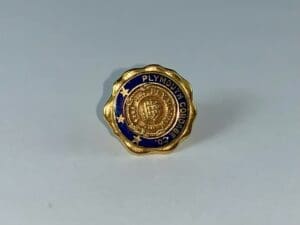 Gold and blue badge with embossed text.