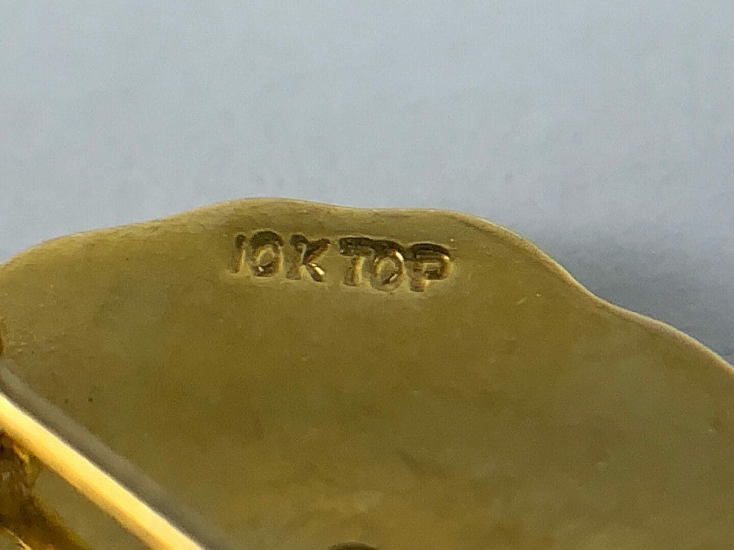 Gold item stamped with "10K TOP".