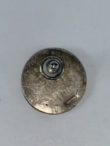Metal button with a central circular detail.