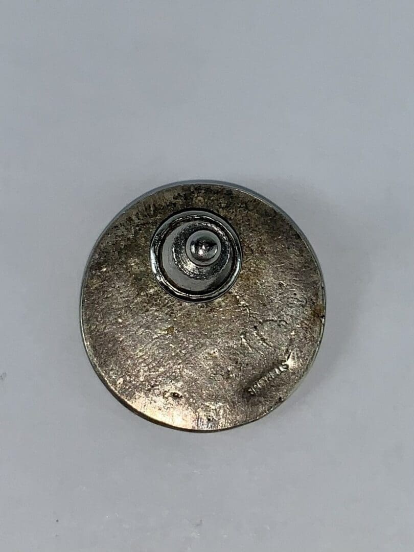 Metal button with a central circular detail.