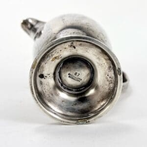Bottom view of a silver teapot base.