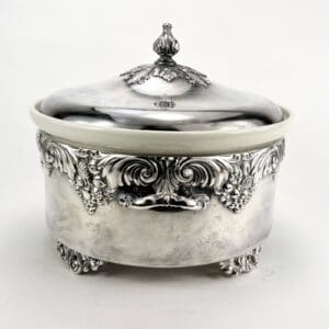 Ornate silver dish with decorative lid.