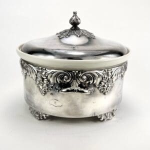 Ornate silver container with lid and engravings.