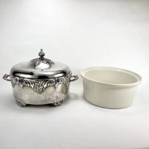 Silver serving dish with white ceramic insert.