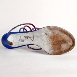 Worn sole of a blue high heel.