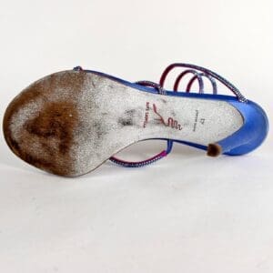 Worn blue sandal with visible dirt underneath.