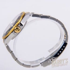 Silver and gold wristwatch on display stand.