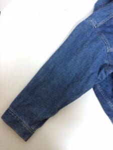 Denim jacket sleeve on white background.