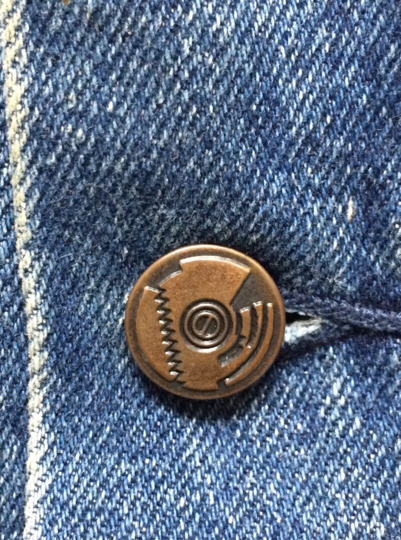 Denim fabric with a metal button detail.