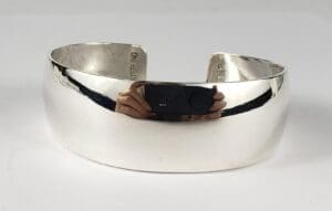 Silver cuff bracelet on white background.