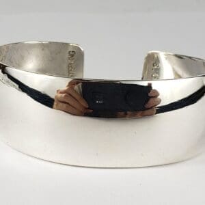 Silver cuff bracelet on white background.