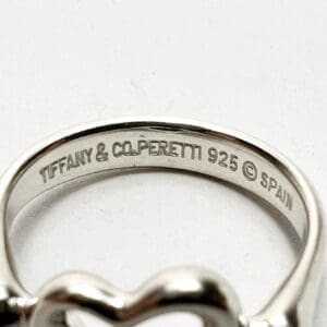 Silver ring with engraved text inside.