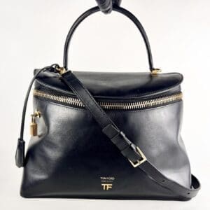 Black leather handbag with gold accents.