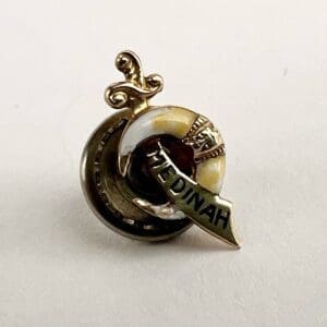 Gold Medinah pin with sword and crescent.