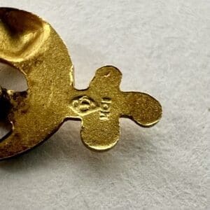 Gold metal piece with engraved numbers.