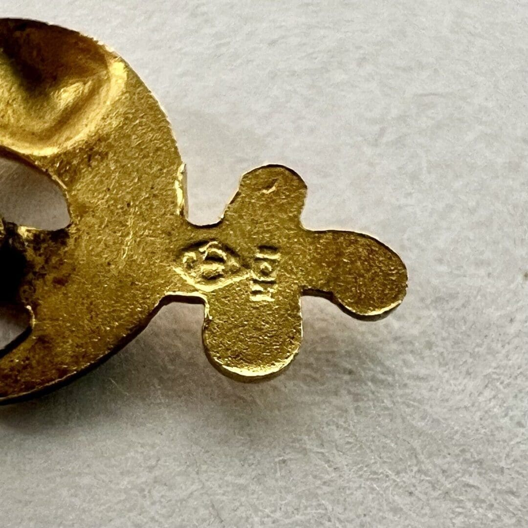 Gold metal piece with engraved numbers.